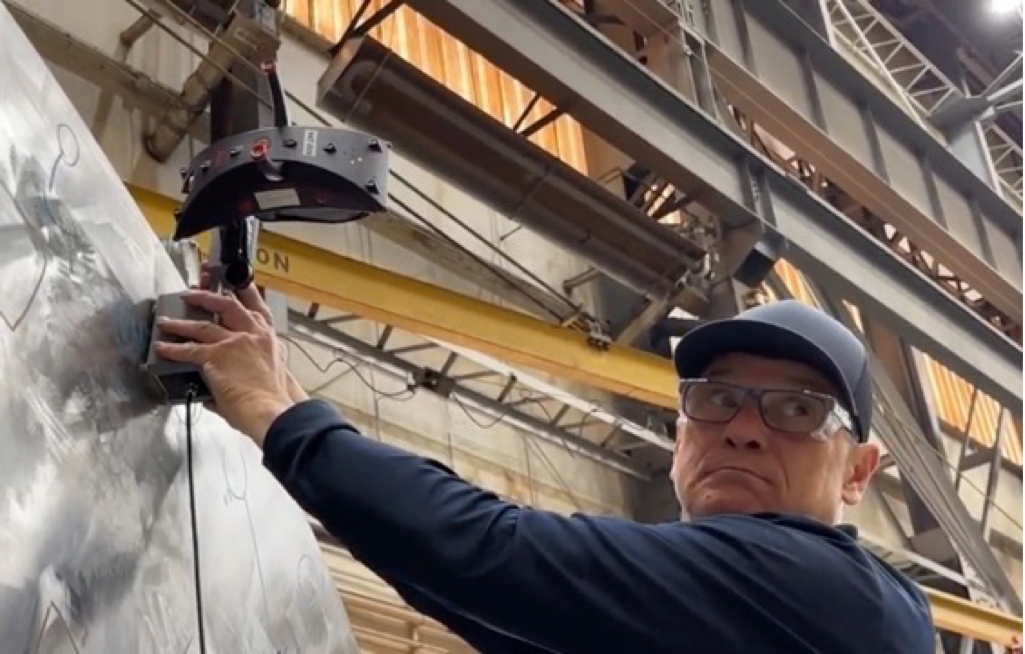 Inspector scanning large industrial structure using handheld probe for digital twin inspection