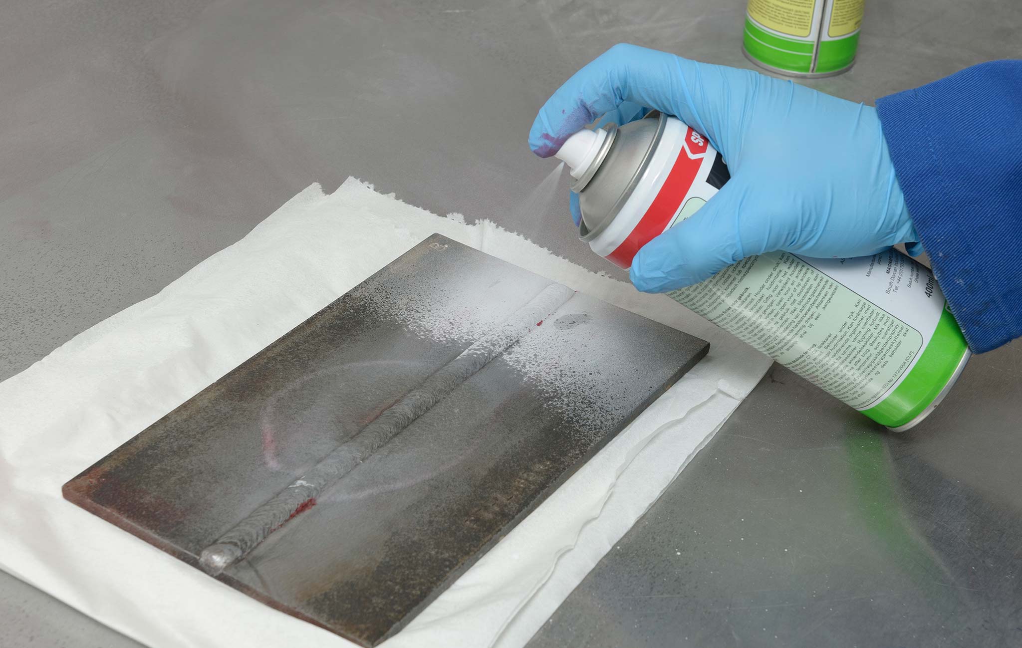Application of penetrant liquid on a material surface as part of the six-stage process