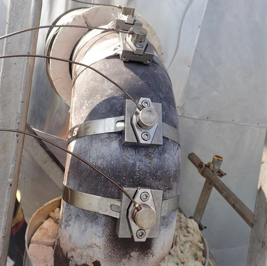 Permanent ultrasonic sensors mounted on insulated refinery pipeline for continuous on-stream corrosion monitoring